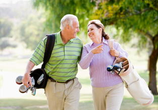 Un couple d'âge moyen jouant au golf par un bel après-midi.