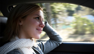 Young woman driving in her car on a sunny afternoon. 