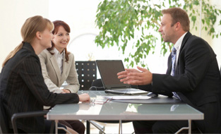 Two women discussing how to use RSPs to save for their future with a financial advisor at the bank.