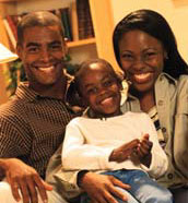 A family smiles in their home.