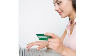 Young woman using her laptop, holding her bank card and ready to log in to use the EasyWeb Tour Tool.
